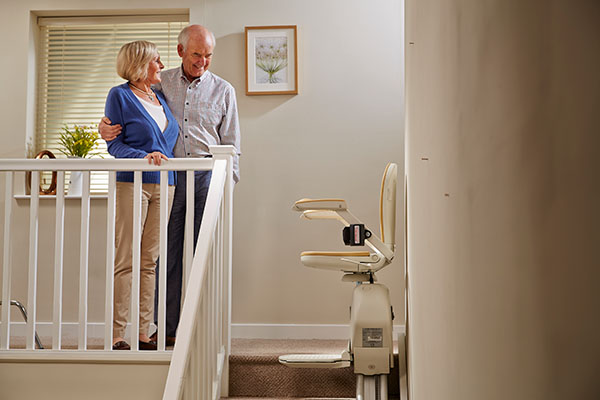 couple looking at stairlift on stairs